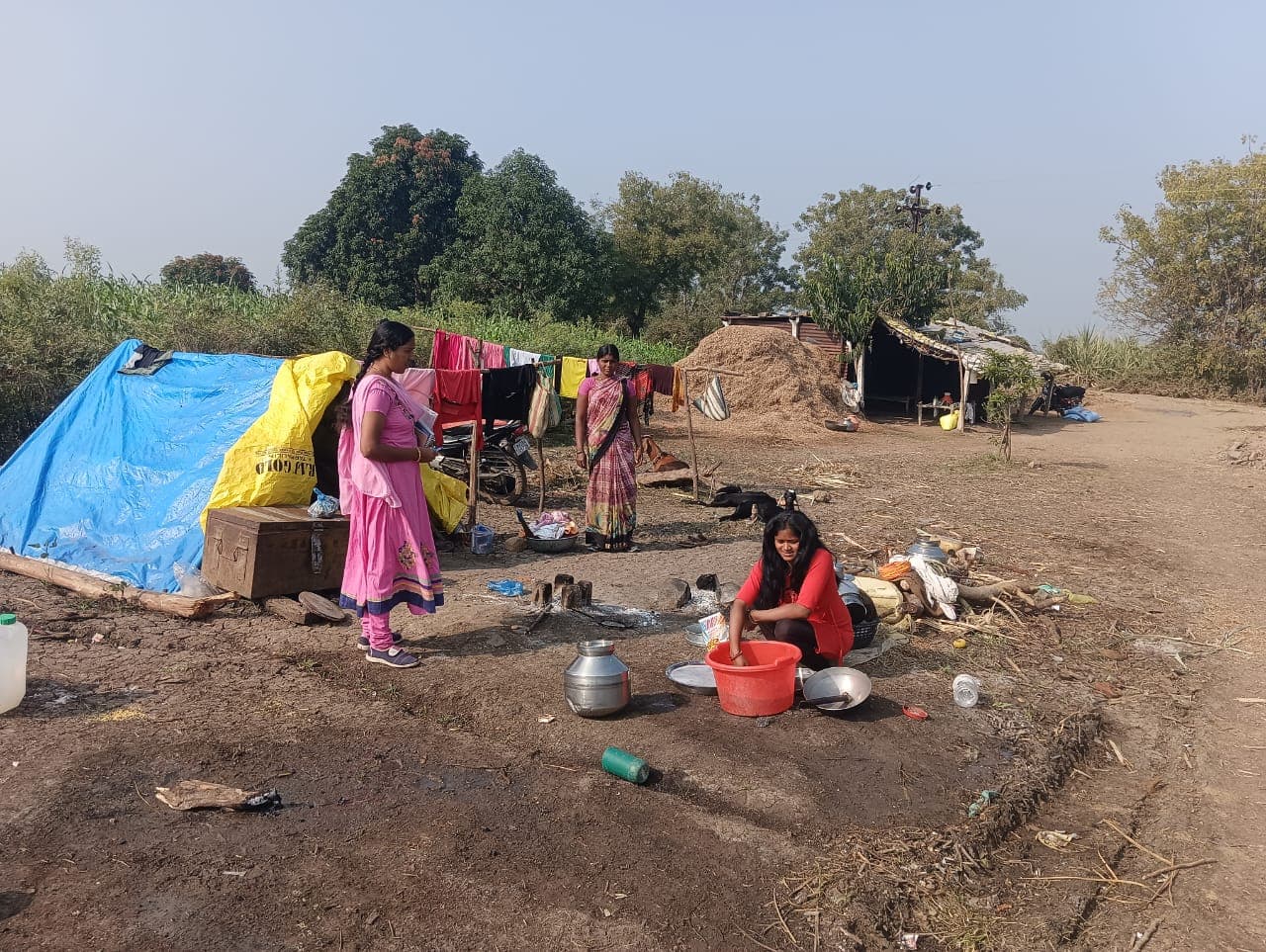 Daily life at a migrant camp, cooking and washing beside the tents