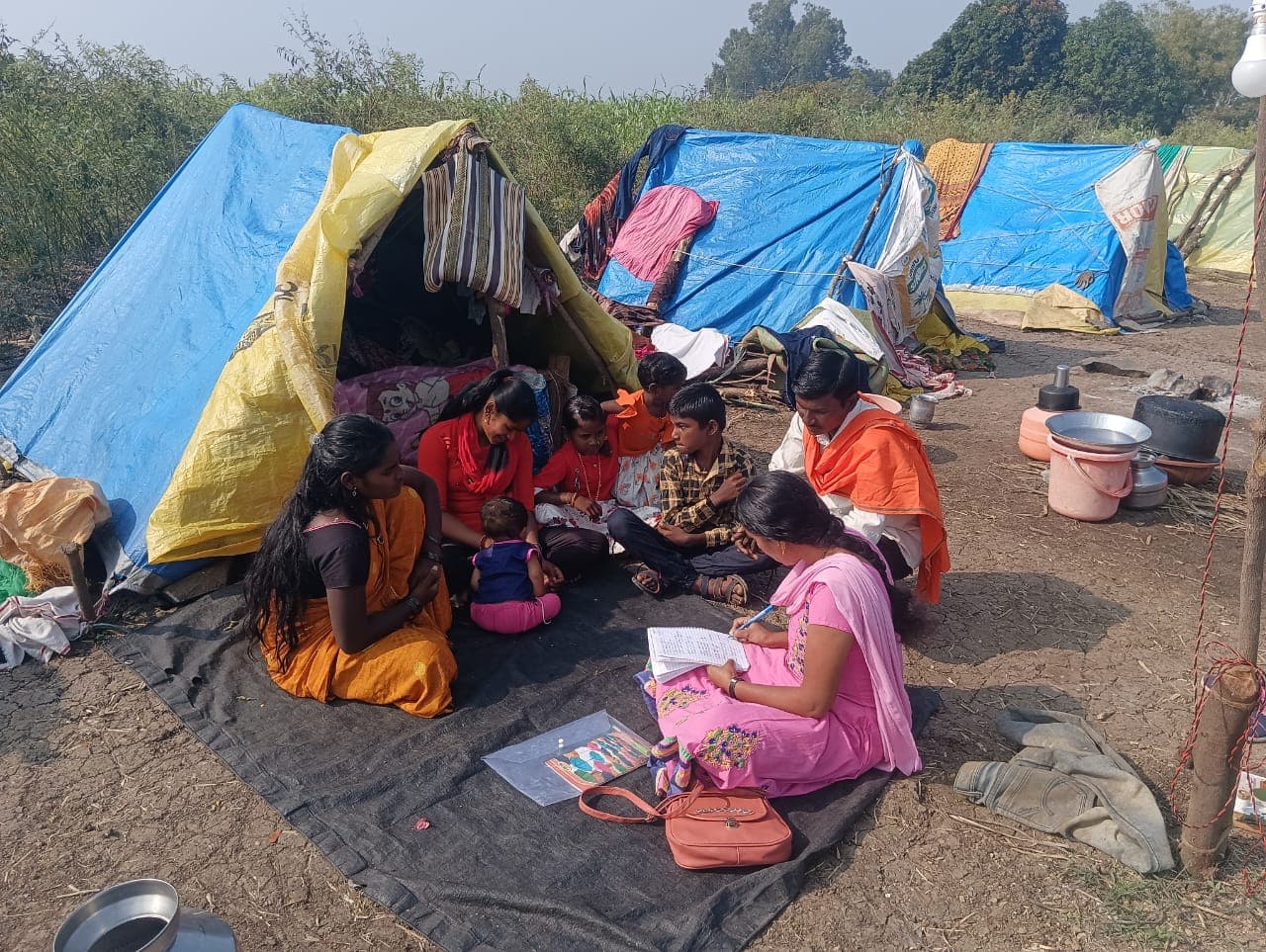 Children studying with their books at a roadside camp