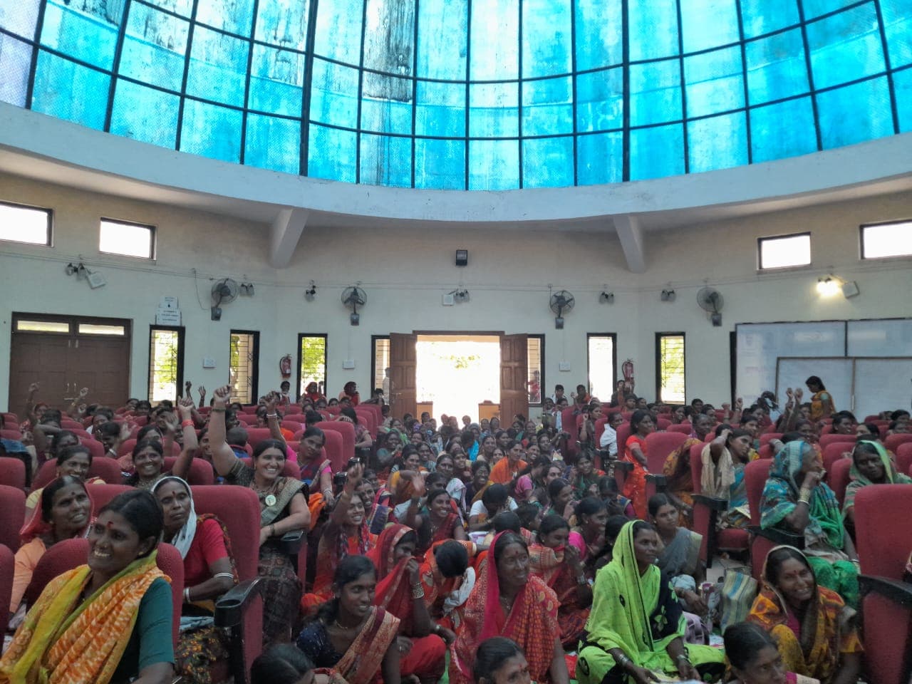 A hall filled with hundreds of women workers at a large gathering